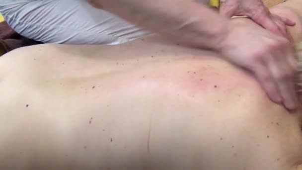 Массировать плечо женщины сильными руками массажистки — стоковое видео
