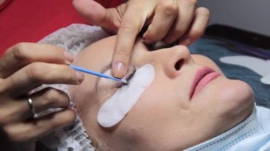 Güzellik salonunda bir kadın kirpik uzatma işlemi geçirir.