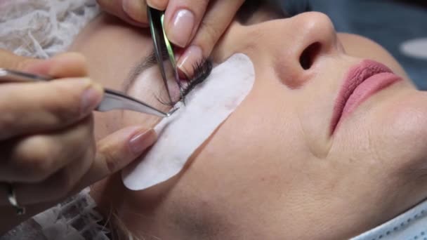 In een schoonheidssalon een vrouw ondergaat een wimper uitbreiding procedure — Stockvideo