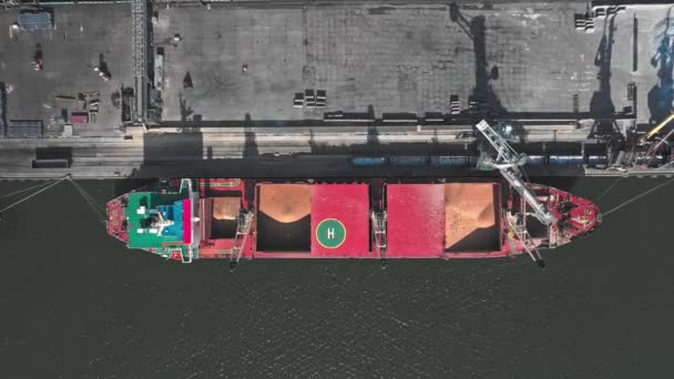 Zicht vanuit de lucht op een vogelperspectief van een vrachtschip voor het vervoer van graan en bulklading. Het schip staat bij de pier. — Stockvideo