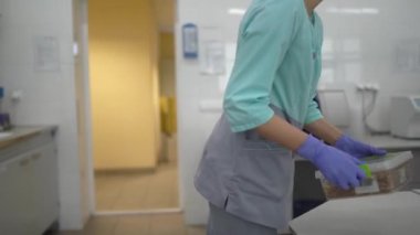 Tahıl almak için bir gıda laboratuvarında, laboratuvar asistanı özel ekipman kullanarak tahıl analizi için plastik bir kap alır ve araştırma odasında değildir.