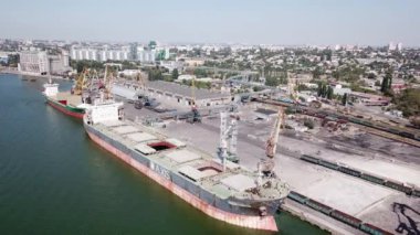 Rusya 'nın limanı, Sivastopol şehri kuş bakışı. Çekim 03.06.2021. Rıhtımda bekleyen büyük bir gemi tahıl mahsullerinin ambarına yükleniyor. Quadrocopter. Doli.