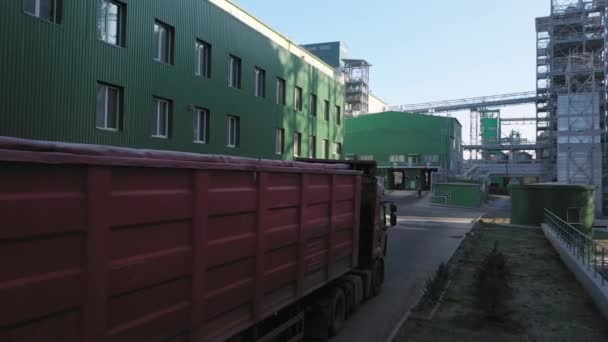 一辆装有拖车的卡车在仓库终端卸货 其他卡车停放在卸货区附近 照相机从后面朝旅行方向飞去 — 图库视频影像
