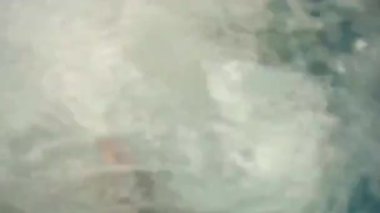 Bir adam elinde GoPro kamerasıyla iskeleden denize atlıyor. Su altında, hava kabarcıkları yüzeye yükseliyor. Yüksek kaliteli FullHD görüntüler
