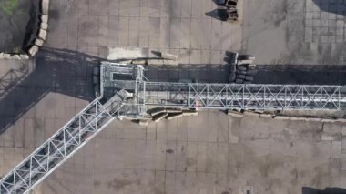 Limandaki iskeleye tahıl teslimatı için metal galerisi üzerinden kameranın uçuşu. Kuş gözü. hava görüntüsü