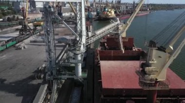 Bir kargo gemisine tahıl yüklüyorlar. Taşıyıcı bant makinesiyle deniz yoluyla taşınmak için. Gemi limanda buğdayla dolu. Buğday ihracatı. Deniz ihracatı. Tarım