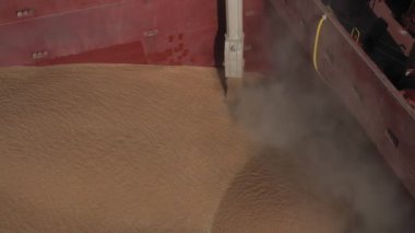 Denizden buğday nakli için limana demirlemiş bir tüccar gemisini yüklemek için taşıyıcı tipi bir yükleme makinesi. Buğday ihracatı. Yakın plan. Kuş bakışı. hava görüntüsü
