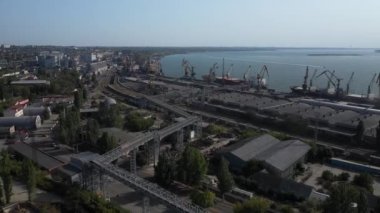 Bir limanda tahıl yükleyen büyük bir geminin üzerinde konveyör makinesiyle kamera uçuşu. Buğday ihracatı. Deniz ihracatı. Tarım. Kuş bakışı. hava görüntüsü