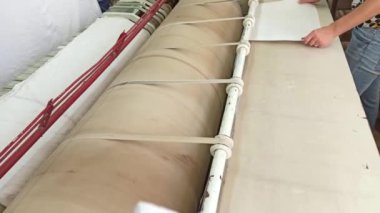 Büyük miktarlarda çamaşır yıkamak için endüstriyel ütü makinesi kullanılıyor.