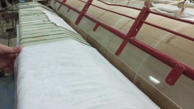 Kadın elleri ütü makinesine beyaz çarşaf koyar.