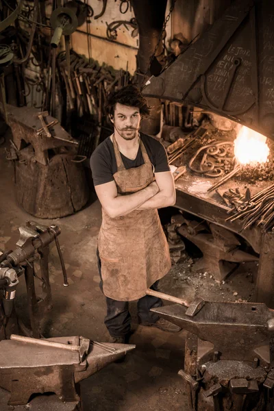 Ironworker forging hot iron in workshop — Stock Photo, Image