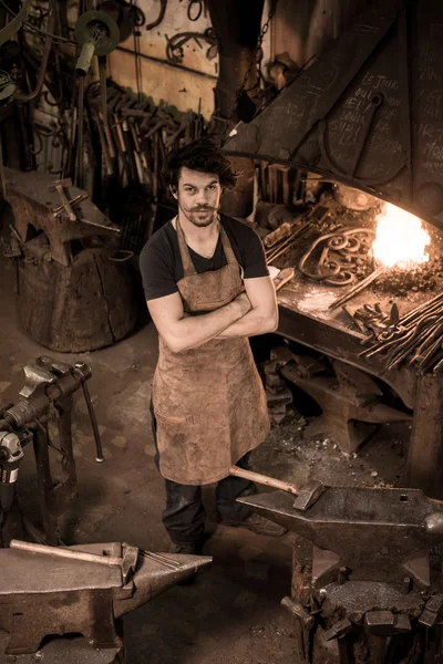 Ironworker forging hot iron in workshop — Stock Photo, Image