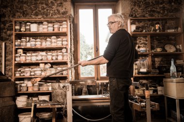Glassblower onun worshop içinde erimiş cam şekillendirme