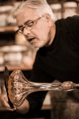 Glassblower onun worshop içinde erimiş cam şekillendirme