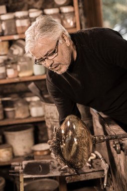 Glassblower onun worshop içinde erimiş cam şekillendirme