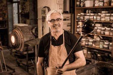 Glassblower onun worshop içinde erimiş cam şekillendirme