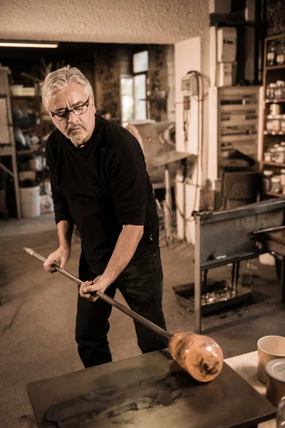Glassblower forming molten glass in his worshop — Stock Photo, Image