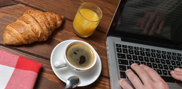 Young guy hands on the wooden table with laptop and coffee — Stock Photo, Image