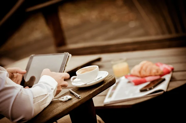 Jovem comendo café da manhã enquanto usando Tablet — Fotografia de Stock