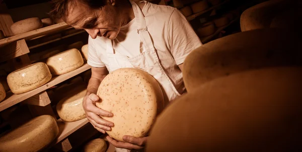 Osttillverkare rengöring ostar i hans verkstad — Stockfoto