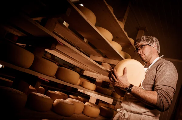 Osttillverkare rengöring ostar i hans verkstad — Stockfoto