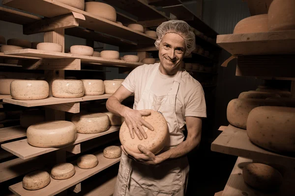 Fabricante de quesos limpiando quesos en su taller — Foto de Stock