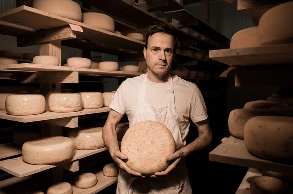 Fabricante de quesos limpiando quesos en su taller — Foto de Stock