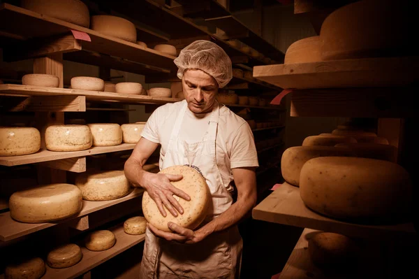 Käsemacher putzt Käse in seiner Werkstatt — Stockfoto
