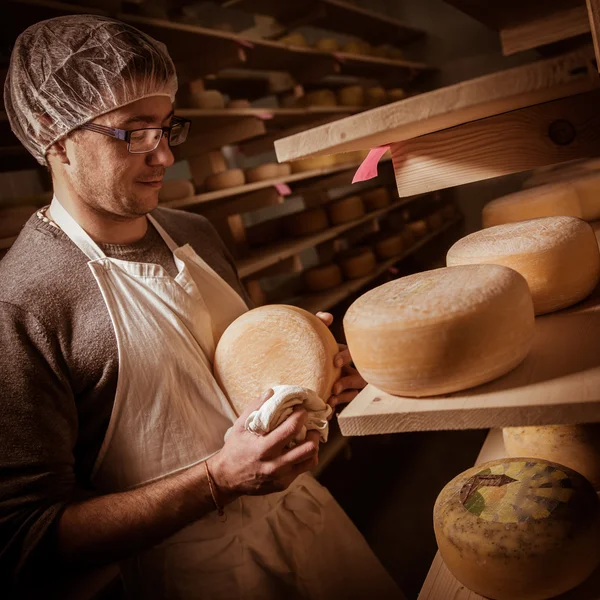 Fabricante de quesos limpiando quesos en su taller — Foto de Stock