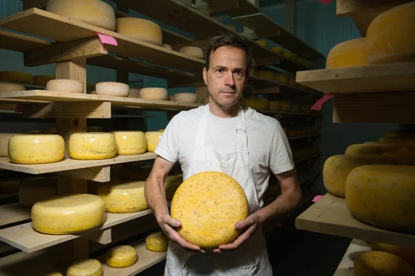 Kaas maker schoonmaken kazen in zijn atelier — Stockfoto