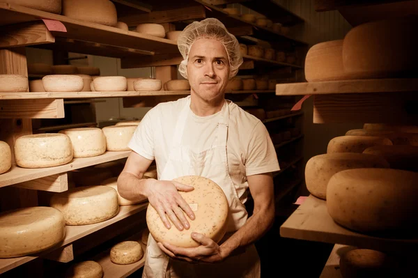 Fabricante de quesos limpiando quesos en su taller — Foto de Stock