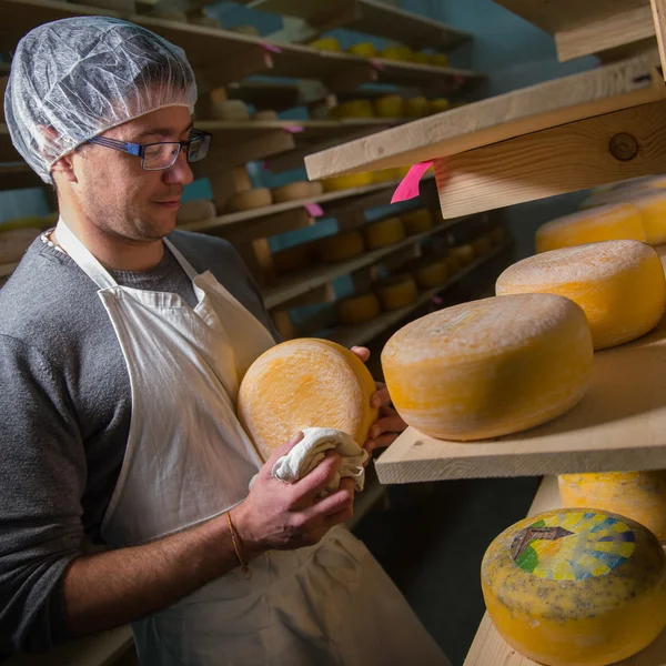 Fabricante de quesos limpiando quesos en su taller — Foto de Stock