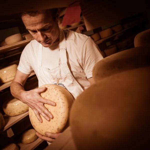 Fabricante de quesos limpiando quesos en su taller — Foto de Stock