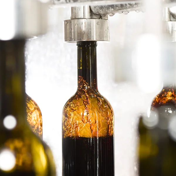 Enchimento de garrafa de vinho ao longo da correia transportadora na fábrica de engarrafamento — Fotografia de Stock