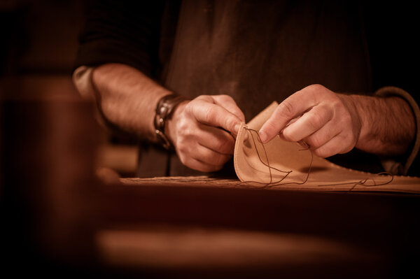 Leather goods craftsman at work in his workshop