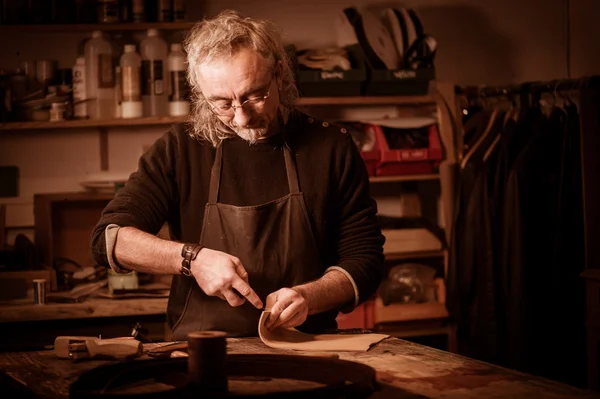 Leather goods craftsman at work in his workshop — Stock Photo, Image