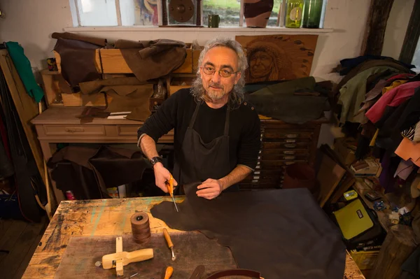 Leather goods craftsman at work in his workshop — Stock Photo, Image