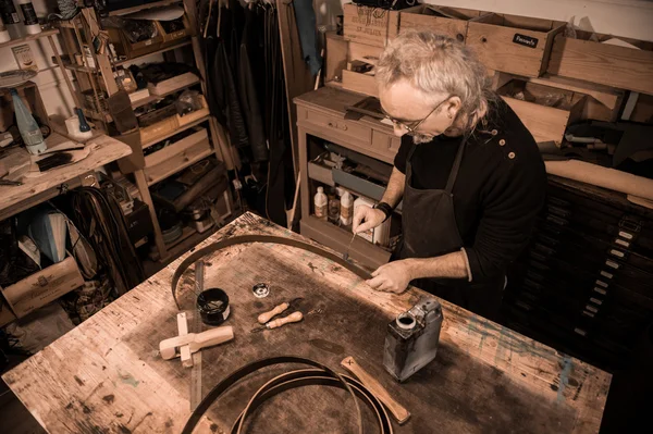 Leather goods craftsman at work in his workshop — Stock Photo, Image