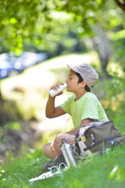 süt içme otların arasında oturan teyoung çocuk
