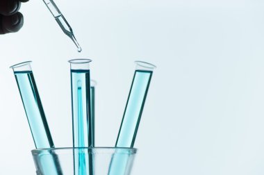 Laboratuvar cam pipetinden test tüpüne sıvı damlası