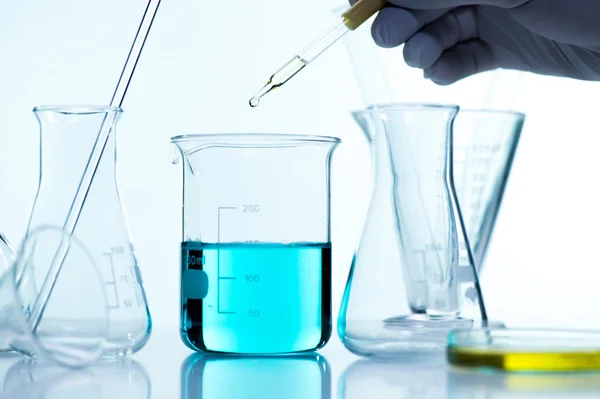 Gota líquida de la pipeta de vidrio del laboratorio al tubo de ensayo —  Fotos de Stock