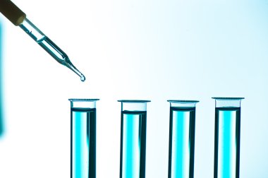 Laboratuvar cam pipetinden test tüpüne sıvı damlası