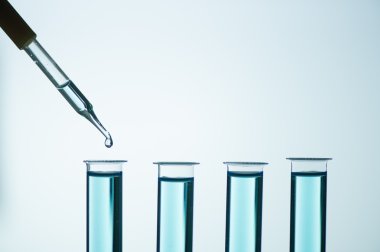Laboratuvar cam pipetinden test tüpüne sıvı damlası