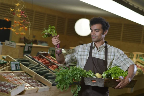 Grocery clerk working in produce aisle of supermarket store — Stock Photo, Image