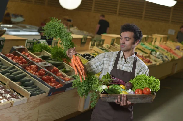 Empleado de comestibles que trabaja en el pasillo de productos de la tienda de supermercados — Foto de Stock