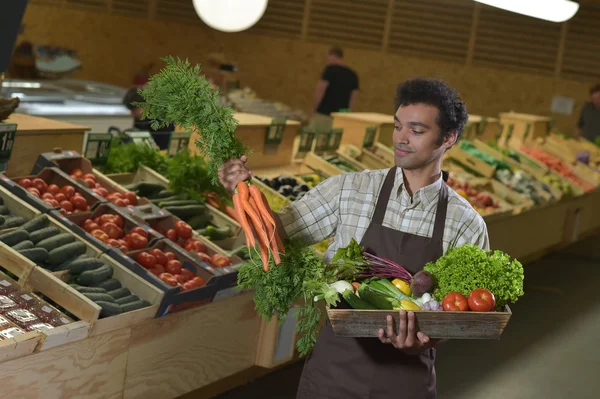 Grocery clerk working in produce aisle of supermarket store — Stock Photo, Image