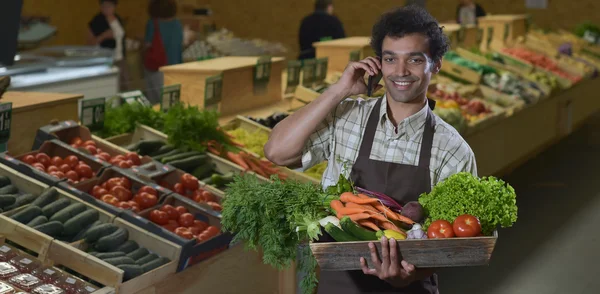 Vendedor de comestibles telefoneando en pasillo de productos de la tienda de supermercados — Foto de Stock