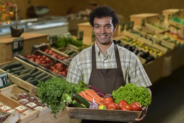 Empleado de comestibles que trabaja en el pasillo de productos de la tienda de supermercados —  Fotos de Stock