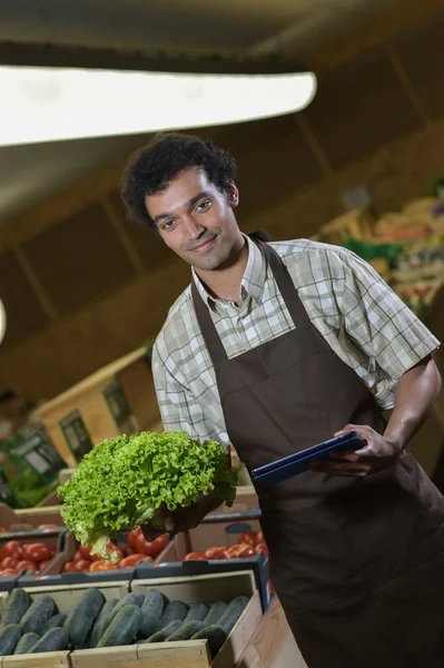 Grocery store employee reading inventory list on digital tablet — Stock Photo, Image