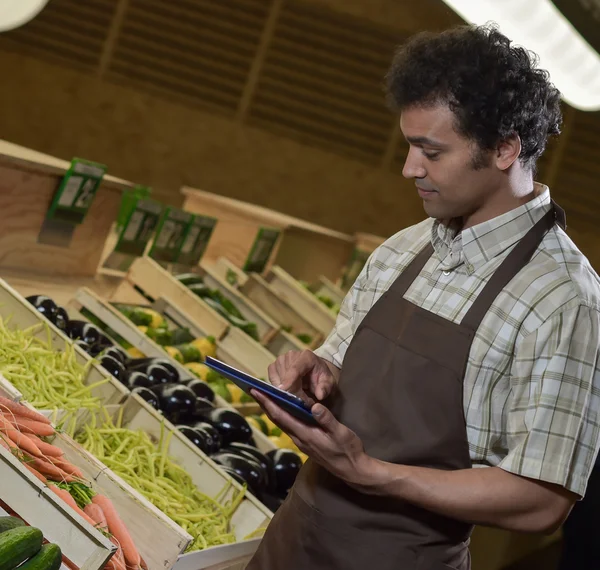 Grocery store employee reading inventory list on digital tablet — Stock Photo, Image